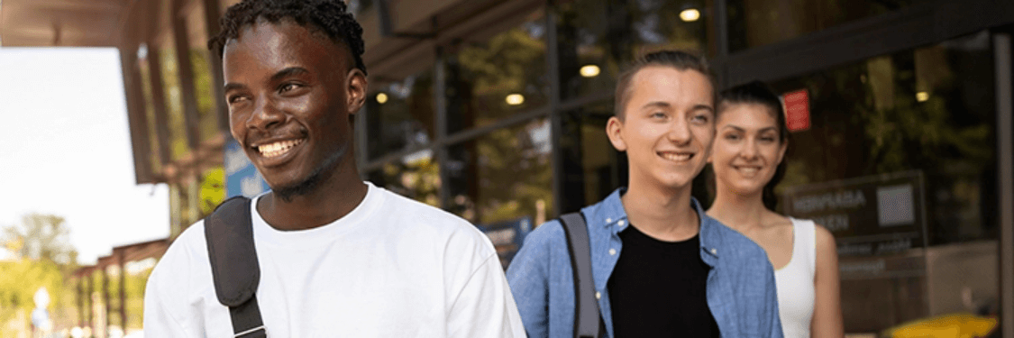 Three diverse high school students walking down the street