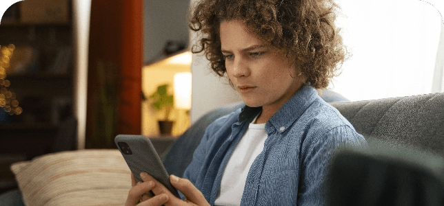 Young white male holding and looking at mobile phone