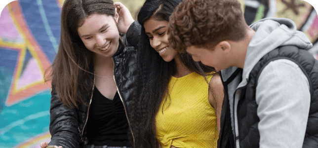 Three diverse kids laughing together