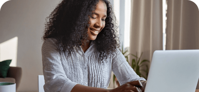 Adult woman typing on laptop in home office